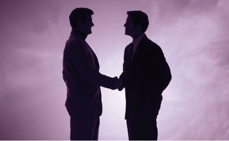 Two men shake hands