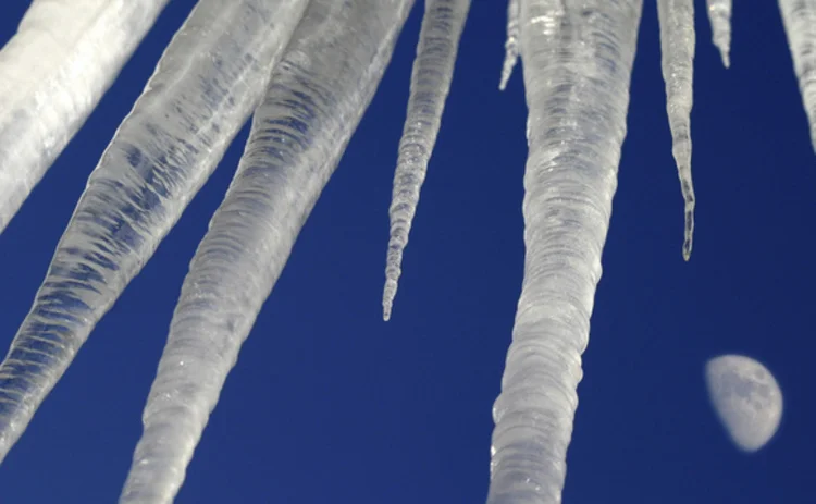icicles-hanging-against-blue-sky-and-moon-closeup