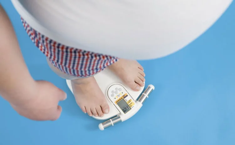 An obese man standing on weighing scales