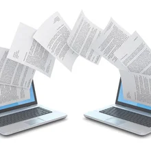 Paper flowing between laptop computers