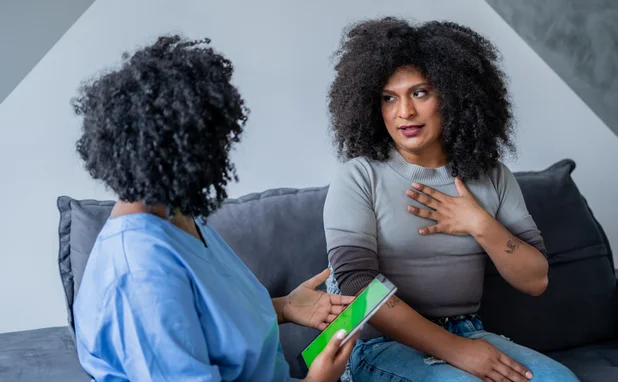 Black nurse consulting trans woman at home