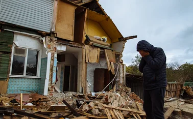 Sad man on ruined house. Hopeless, homelessness, result of military conflicts and natural disasters concept.