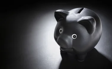 Black piggy bank on blackboard background