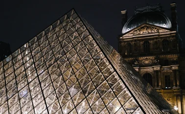 Paris, France – February 15, 2020: Night view of the Louvre Pyramid and the historic Louvre Palace in Paris, France, illuminated with lights.