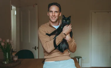 Henri Dowling holding his cat Ivy.
