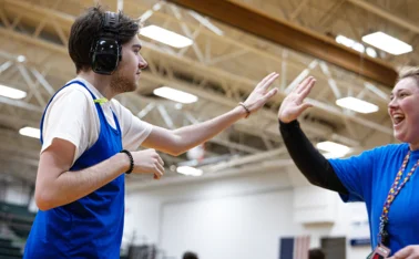 Neurodivergent man high fives his coach 