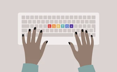 Hands typing on a keyboard, top view, rainbow buttons with an LGBTQ+ sign, queer community support