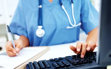 A NHS doctor working at a computer