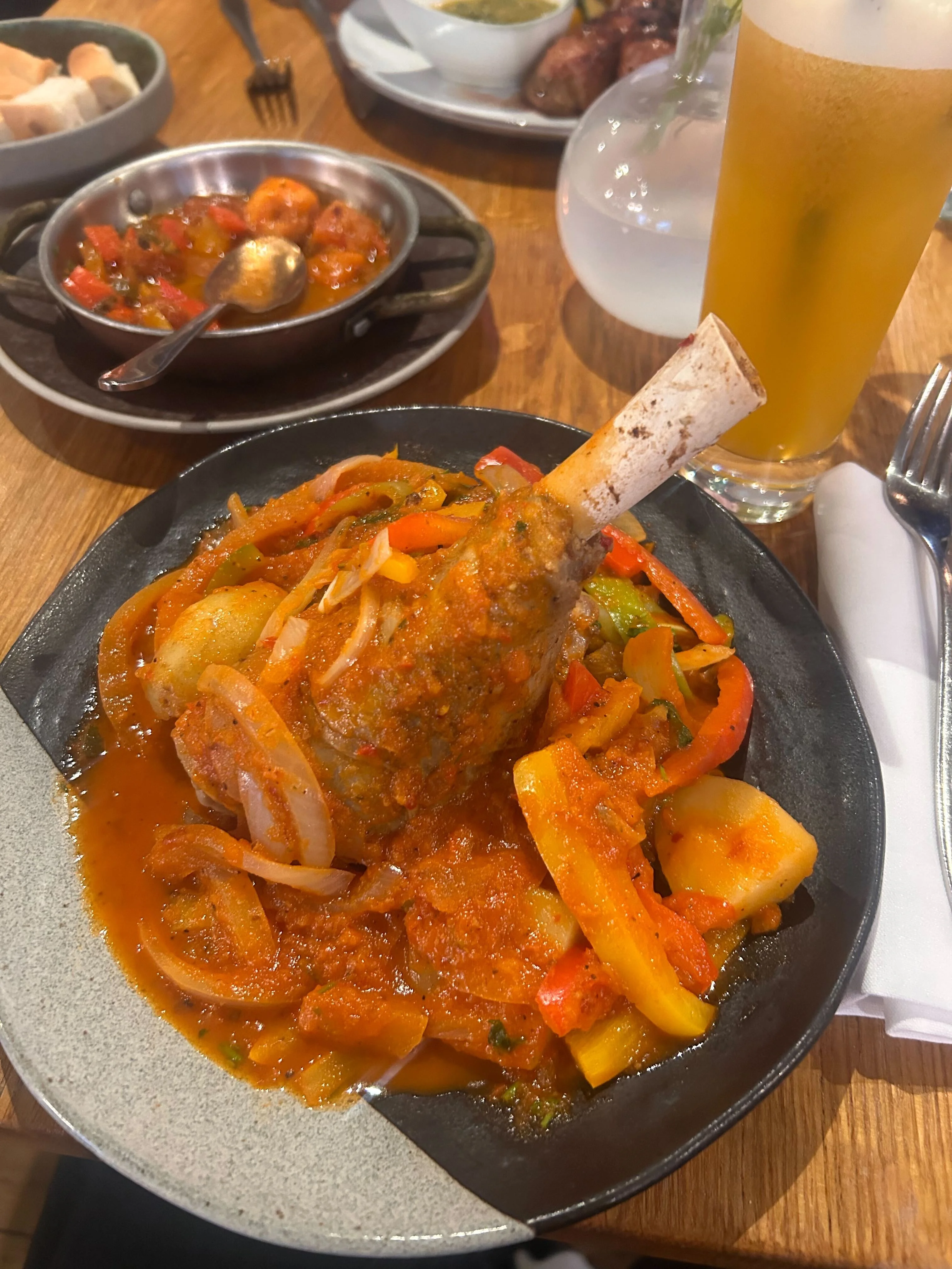 Lamb shank served in a balck plate.