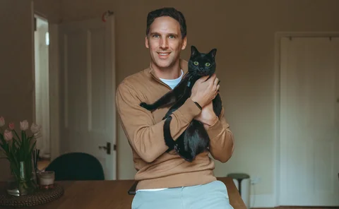 Henri Dowling holding his cat Ivy.