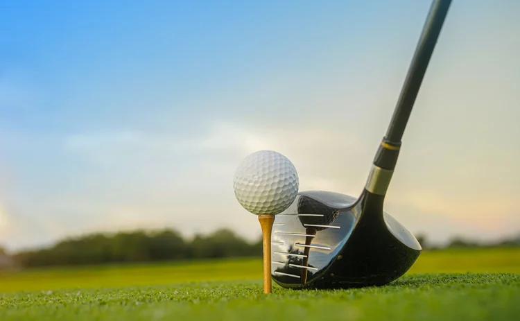 Golf clubs and balls on a green lawn in a beautiful golf course with morning sunshine