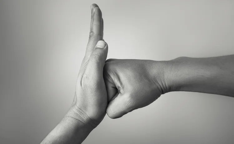 Hand preventing stopping punch attack of another hand.