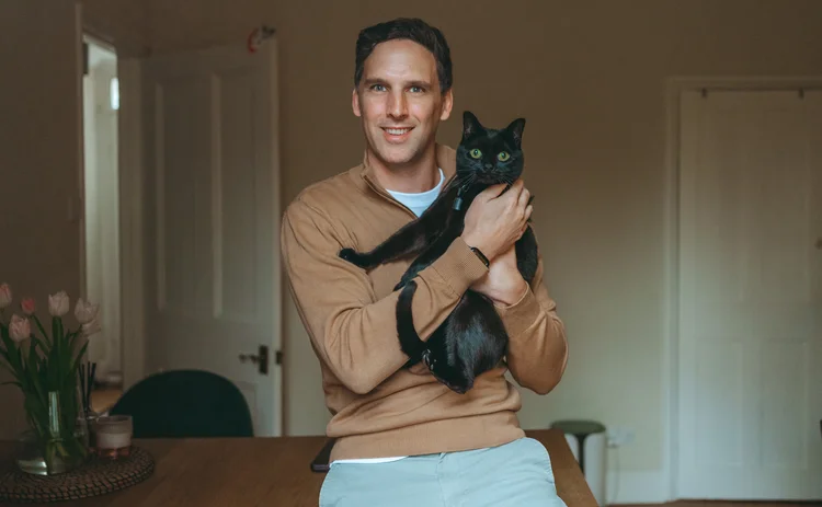 Henri Dowling holding his cat Ivy.
