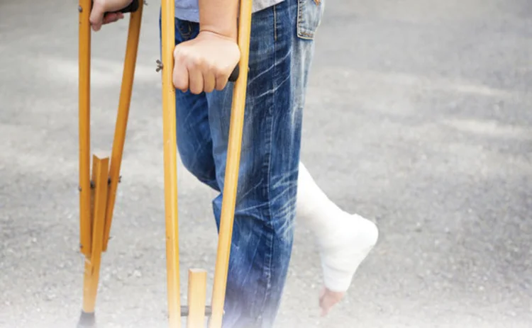 A person on crutches with their leg in plaster