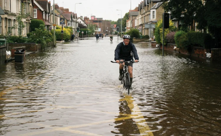 Cyclist riding through flooded road