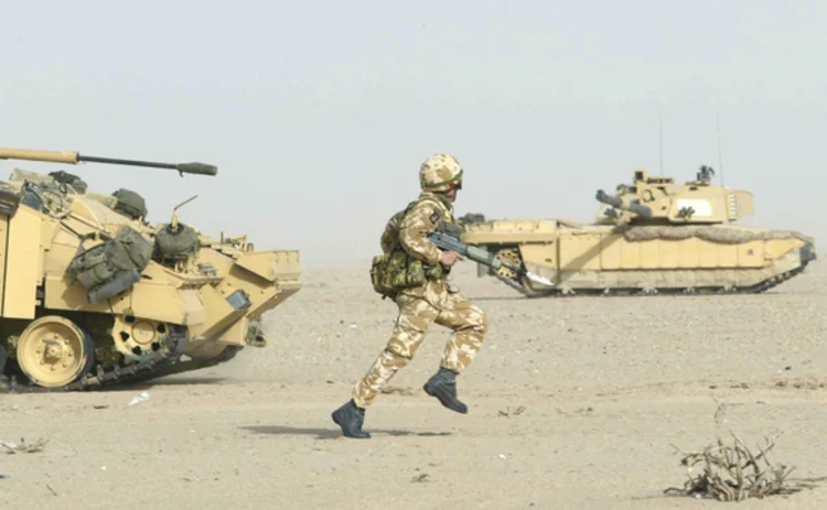Desert soldier running amongst friendly tanks