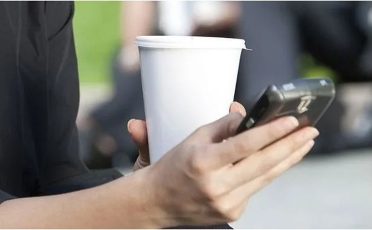 woman using blackberry drinking coffee