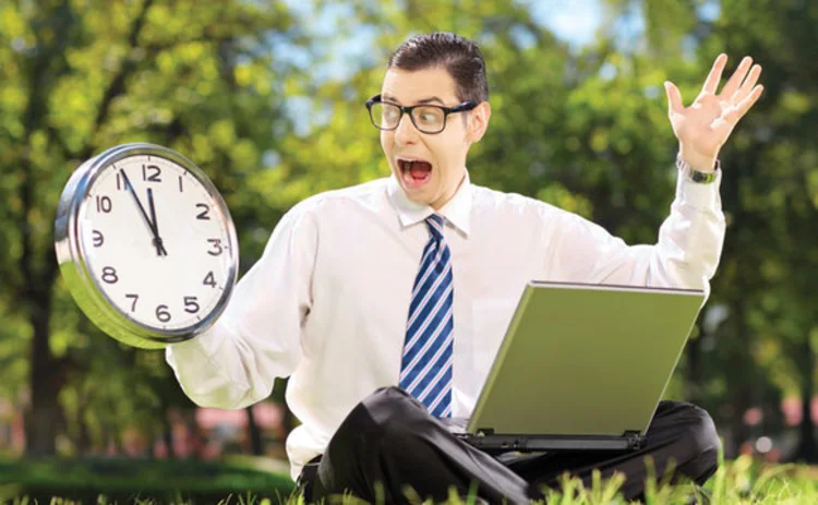 A stressed looking businessman holding a clock