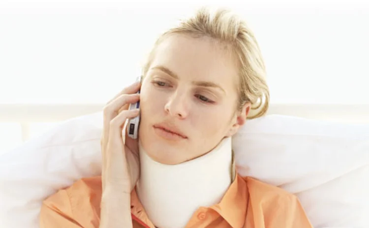 A woman with whiplash talking on the phone