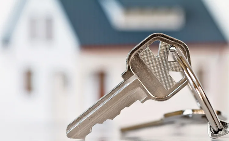 A set of keys in front of a model house