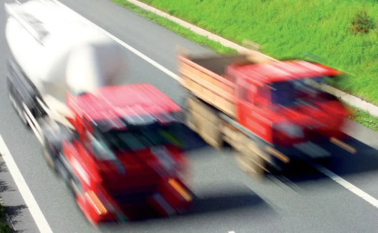 Two red trucks on a road