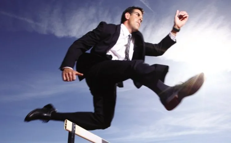 Businessman jumping a hurdle