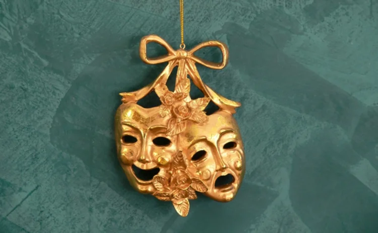 gold-comedy-tragedy-mask-hanging-on-green-background