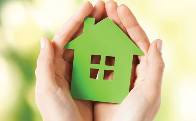 Hands cupping a cutout of a house