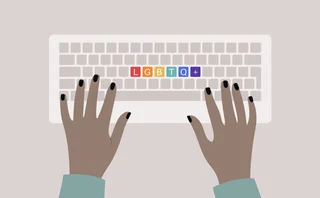 Hands typing on a keyboard, top view, rainbow buttons with an LGBTQ+ sign, queer community support