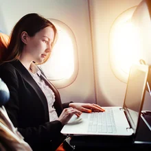 Female businesswoman working on laptop on an aeroplane