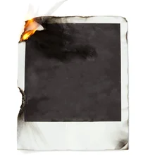 Polaroid photo on fire, damaged. Use the blank smudged and aged black background or replace it with your own image.