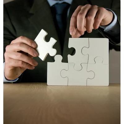 A man putting the final piece of a jigsaw together