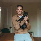 Henri Dowling holding his cat Ivy.